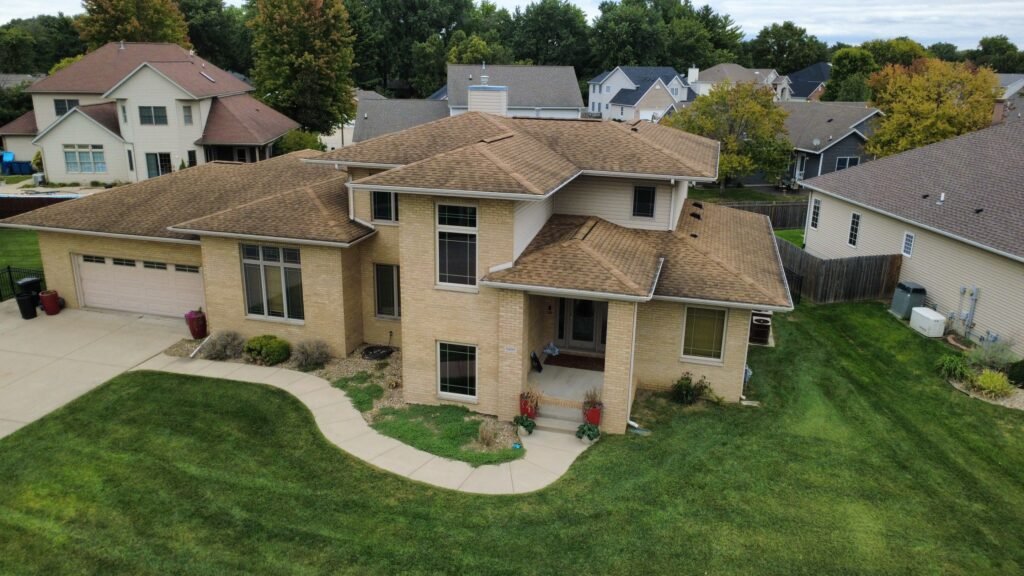 Wide aerial front view of a Springfield, IL home with its old brown shingle roof before replacement