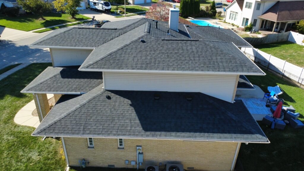 Aerial rear view of new dark IKO Dynasty shingles on the multi-level hip roof of a Springfield, IL home