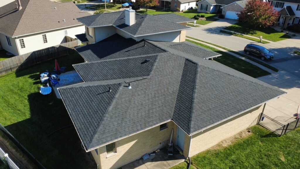 Aerial side view of a newly replaced hip roof with dark IKO Dynasty shingles on a Springfield, IL home