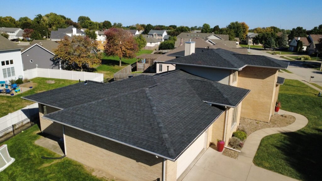Completed IKO Dynasty Blackstone roof over the garage and living areas of a Springfield, IL home, with the neighborhood behind it