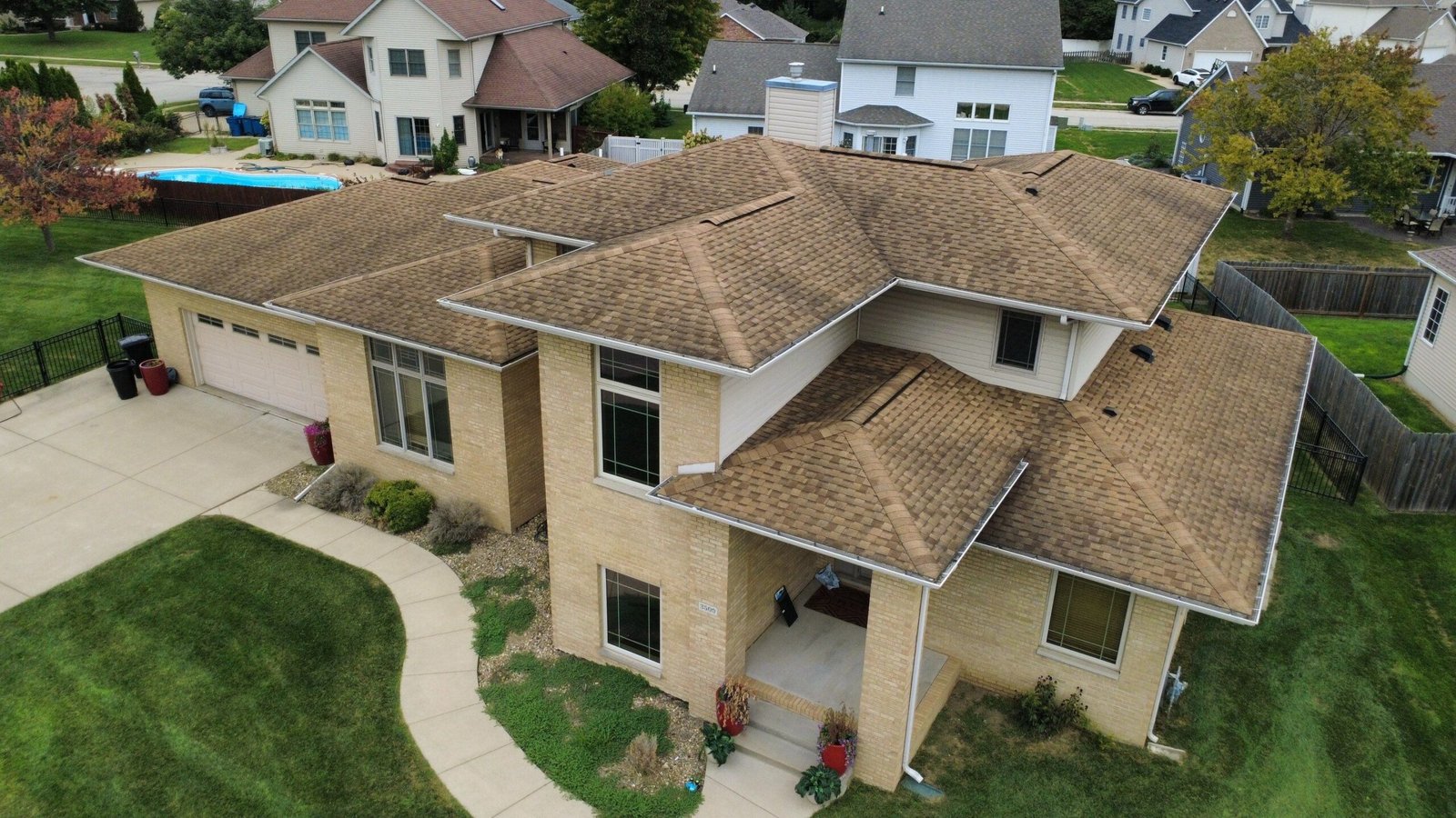 Aerial front view of a Springfield, IL home with its old, weathered brown asphalt shingle roof before replacement