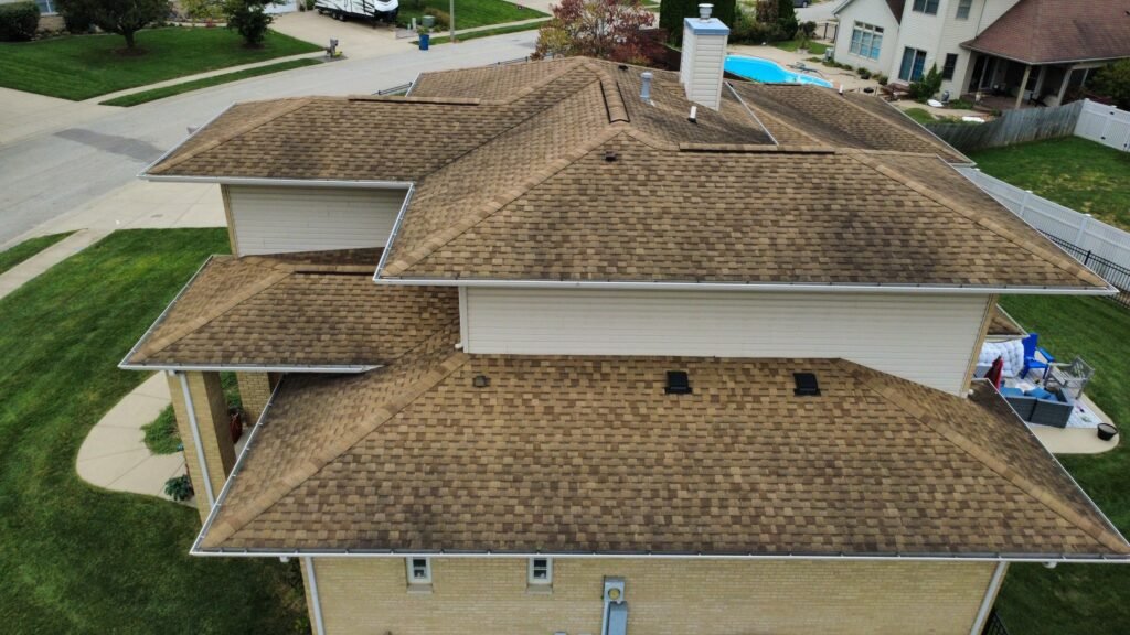 Aged brown shingles on the multi-level hip roof of a Springfield, IL home before Westside Construction's roof replacement