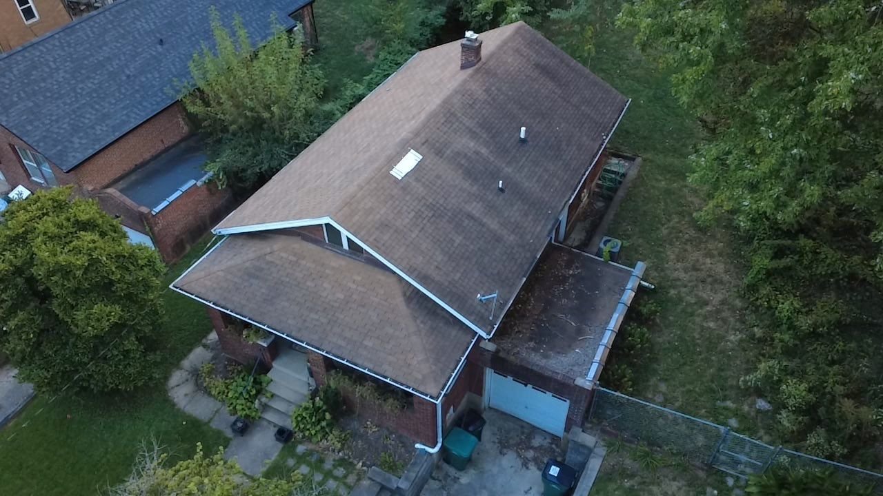 Angled aerial view of the worn brown shingle roof on a Webster Groves, MO bungalow before replacement