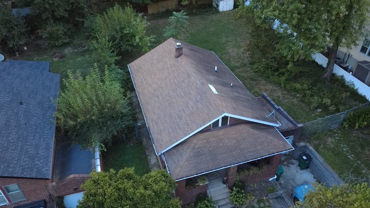 Aerial view of a faded, streaked brown shingle roof on a Webster Groves, MO bungalow before replacement