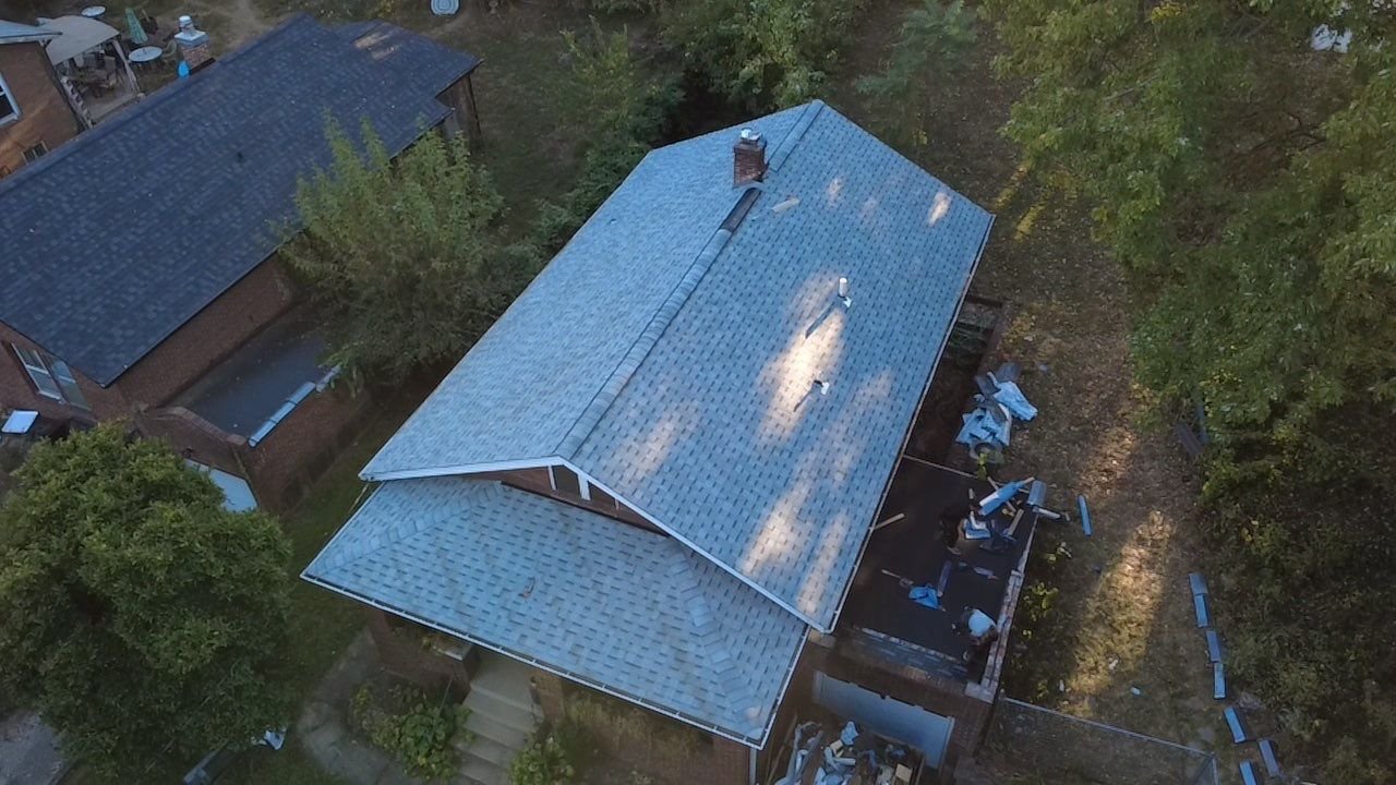 Angled aerial view of the new IKO Cambridge Dual Grey roof on a Webster Groves, MO bungalow as the crew finishes cleanup