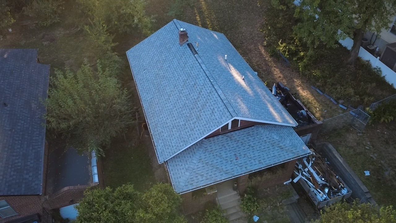 Aerial view of a red brick Webster Groves, MO bungalow with a new IKO Cambridge Dual Grey shingle roof installed by Westside Construction